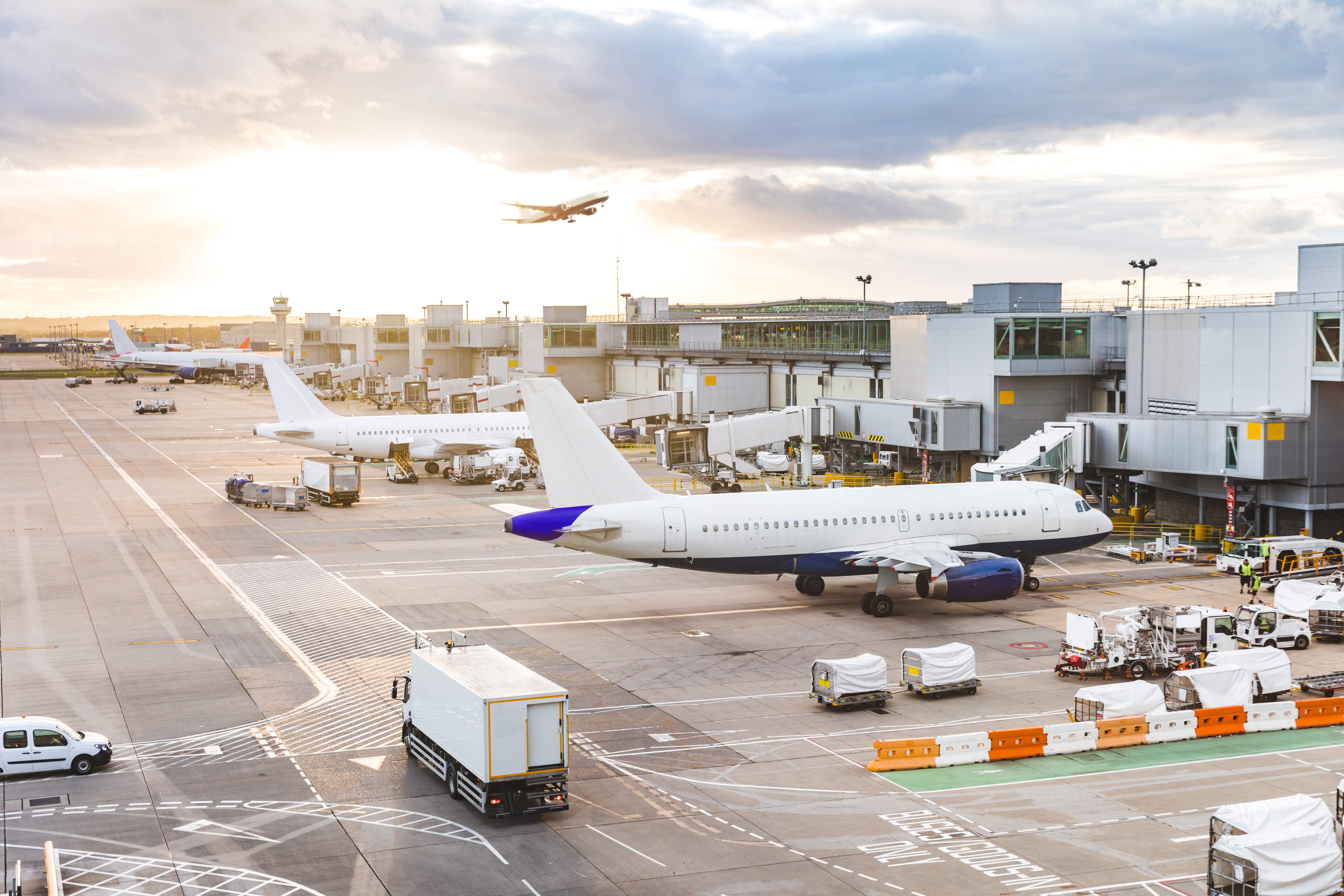 Flughafen mit mehreren Flugzeugen und Frachtaktivitäten, symbolisiert moderne Luftfracht-Logistik und die Digitalisierung in der Logistikbranche.