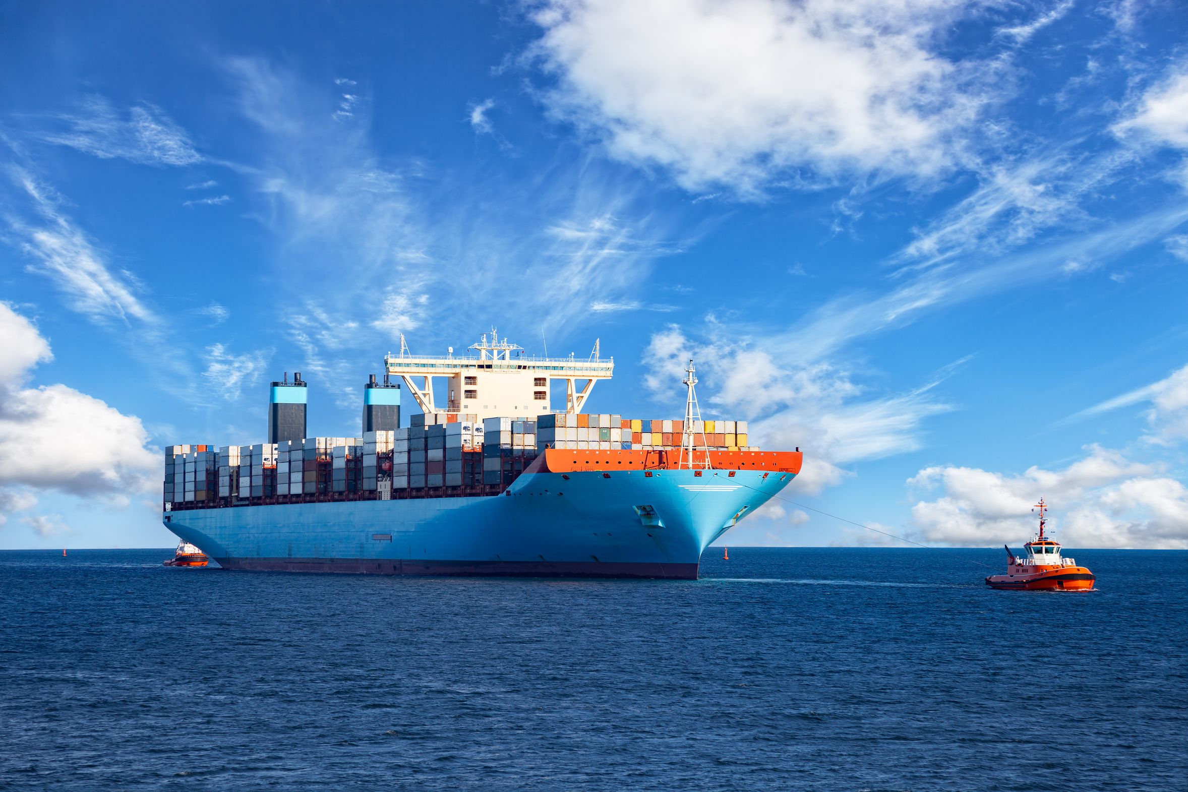 Begleitboot unterstützt Cargo-Schiff bei der Einfahrt in den Hafen.