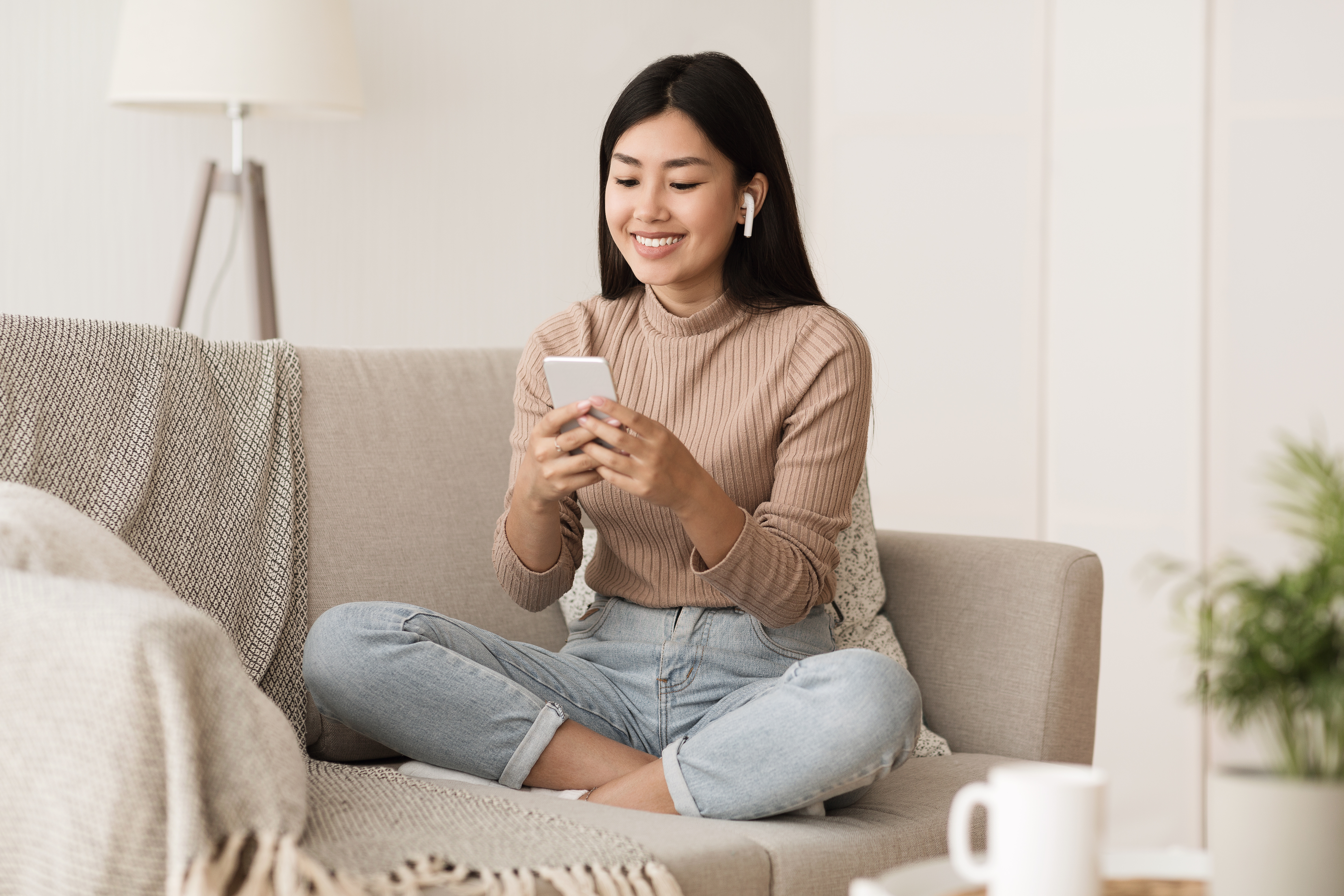 Student Girl Relaxing on Couch at Home with Phone