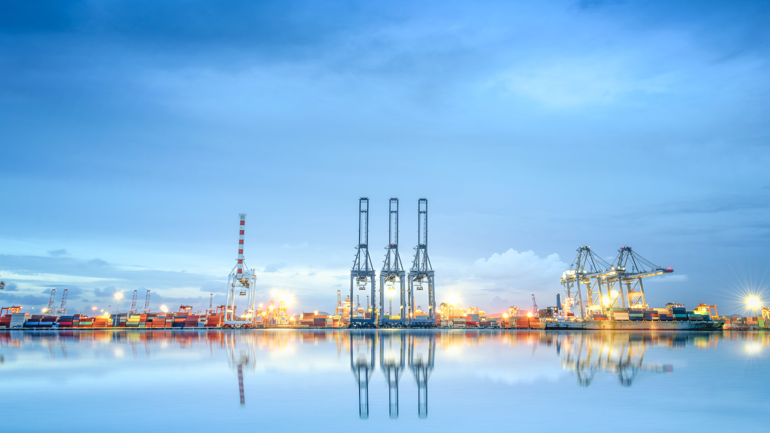 Logistik und Transport des Internationalen Container-Frachtschiffes in einem Hafen mit Wasserreflexionen für den logistischen Import-Export und die Transportindustrie.